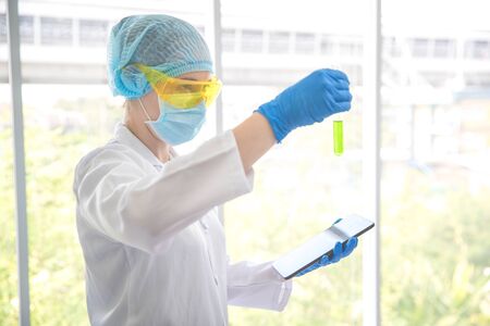 scientist woman checking and recording the results using as science research background.の写真素材