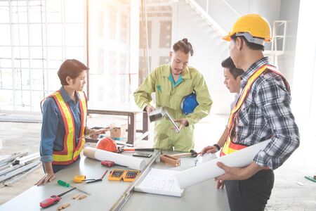 engineer people working and discussing with architecture or blueprint at construction siteの写真素材