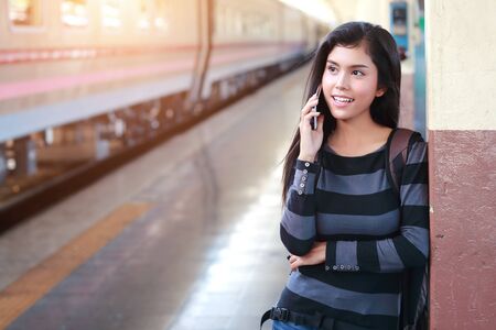 young traveler woman with backpack using smart phone during traveling on holidayの写真素材