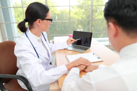 doctor comforting and holding hand male patient with care (medical concept)の写真素材