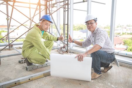 engineer people working and discussing with architecture or blueprint at construction siteの写真素材