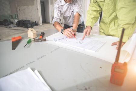 engineer people working and discussing with architecture or blueprint at construction siteの写真素材
