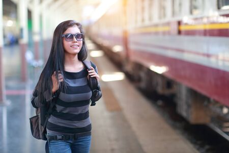 young traveler woman with backpack waiting for trainの写真素材