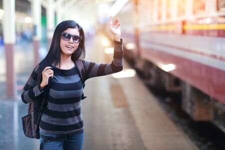 young traveler woman with backpack waiting for trainの写真素材