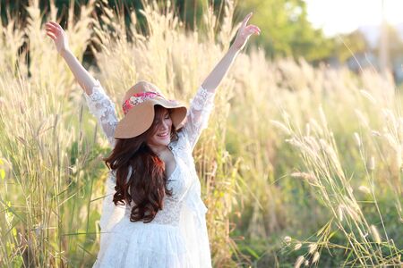 portrait of beautiful woman having a happy time and enjoying among grass field in natureの写真素材