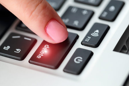 human hand press delete button on computer keyboard