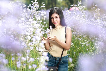 portrait of beautiful woman having a happy time and enjoying among flower Naga-crested field in natureの写真素材