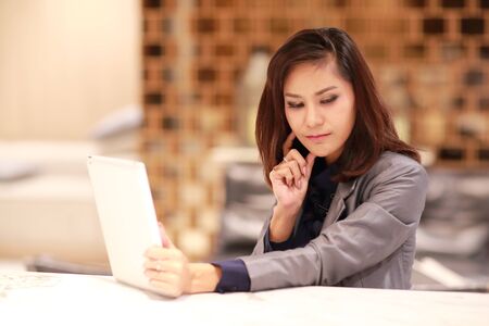 portrait of beautiful businesswoman post using table and thinkingの写真素材