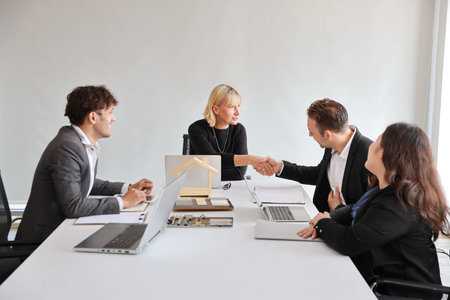 Multiethnic business people discussing company about new house project in meeting room then they...