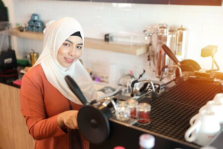 young muslim barista girl making coffeeの写真素材