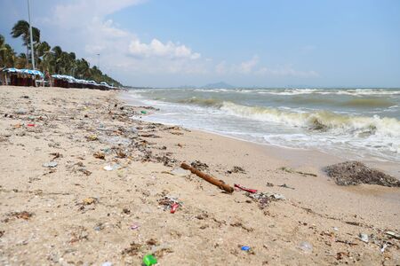 low angle view image of empty plastic water bottle on dirty beach filled with plastic pollution, garbage and waste on dirty sandy beach, nobodyの写真素材
