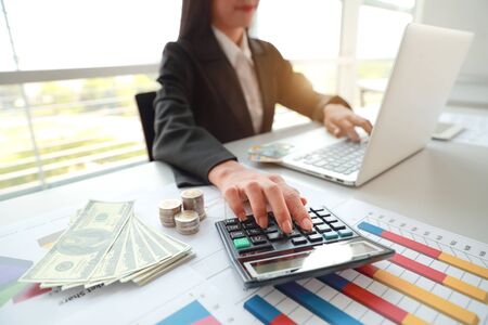 businesswoman using laptop computer while working on company summary report with graphの写真素材