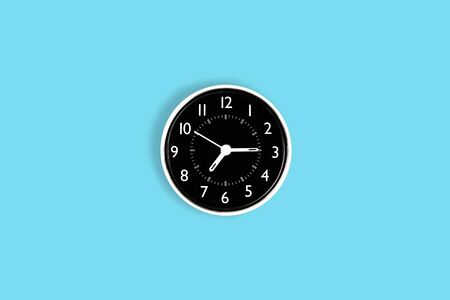 white time clock on blue pastel desk or wallの写真素材