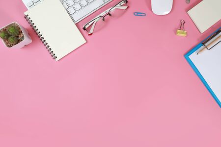 flat lay workspace table with laptop computer, office supplies, coffee cup, cell phone, and coffee cup on pink backgroundの写真素材