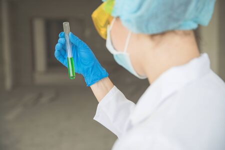 scientist woman with equipment and laboratory glassware holding chemical liquid and checking result using as science research backgroundの写真素材