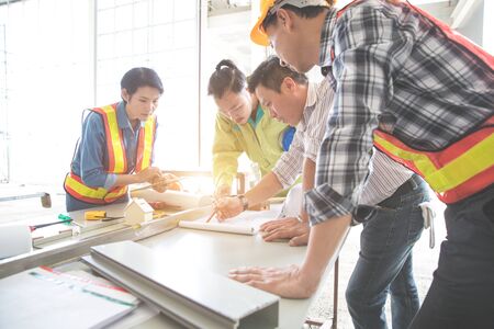 engineer people working and discussing with architecture or blueprint at construction siteの写真素材