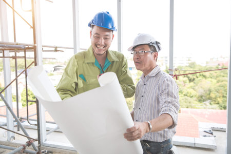 engineer people working and discussing with architecture or blueprint at construction site