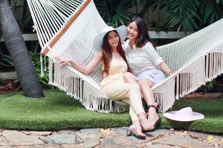 young and cute asian women lying in a hammock during holidayの写真素材