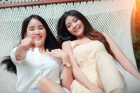 young and cute asian women lying in a hammock during holidayの写真素材