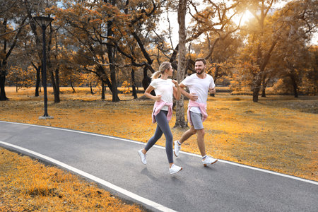 young and healthy couple people are in love jogging in the park during autumn season (healthy or...