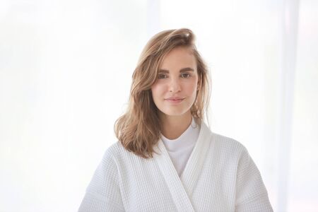 young and healthy caucasian girl portrait in white pajama standing in bedroom in the morningの写真素材