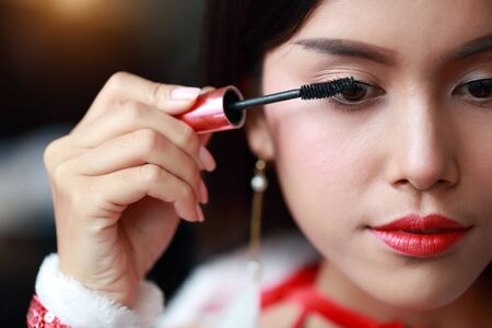 young asian santa girl applying eye shadow on beautiful faceの写真素材