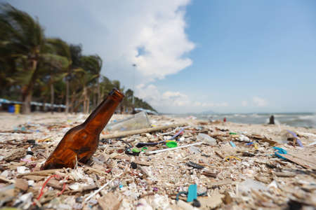 Pictures of dirty beach filled with empty bottle and plastic pollution, garbage and waste on sandyの写真素材