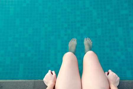 woman legs in swimming pool on holiday vacationの写真素材