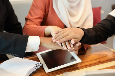 businessman and businesswoman muslim meeting and stacking hands (partner or success business...