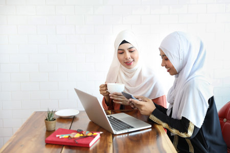 new generation businesswoman muslim people meeting in coffee shop with computer and coffee cup on...