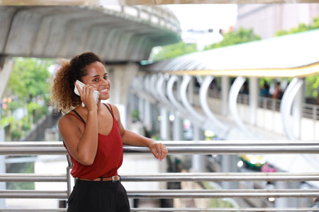 successful caucasian businesswoman in casual dress standing in downtown, he using cell phone with...