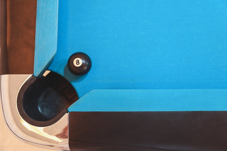 black billiard number 8 on blue pool table