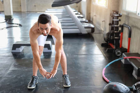 Handsome caucasian man with a mustache do stretching exercise in fitness gymの写真素材