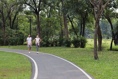 young caucasian couple people who wearing sport suit are in love. talking and walking in the park...