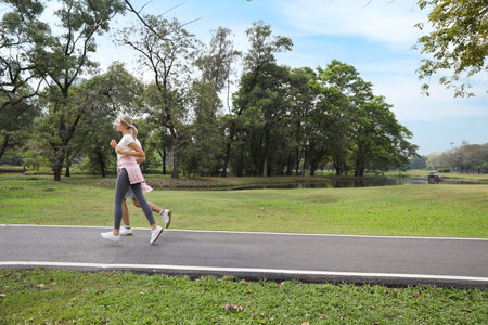 a runner caucasian couple is jogging in the park during summer season (healthy or sport concept)
