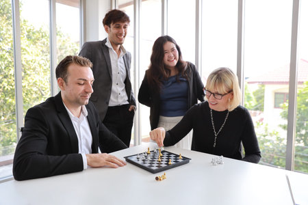 caucasian of businessman and businesswoman are playing chess with multiethnic business people,...