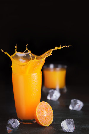 Fresh homemade orange juice in glass with ice on vintage wooden table. Freshness beverage with...