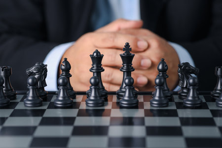 Businessman in black suit sitting and control team in front to success position on competition business game, meaning of success planning and strategy decision and achievement goal concept.の写真素材