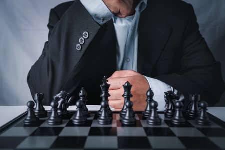 Businessman in black suit sitting and control team in front to success position on competition business game, meaning of success planning and strategy decision and achievement goal concept.の写真素材