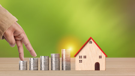 Business property investment concept, man hand walking on stacking coins saving growth on wooden...