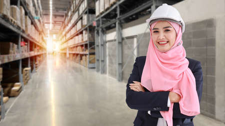 Asian muslim worker woman portrait standing in suit with confident and looking at camera with large warehouse backgroundの写真素材