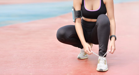 Cropped image of asian woman in sportswear jogging outdoor with slim athletic legs. Sporty girl...