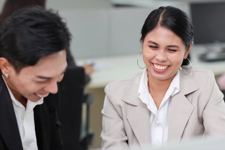 Business people gossiper group whispering or sharing rumor about their colleague in the office. Female coworker sitting and telling gossip to male workmate about bullying problem at work placeの写真素材