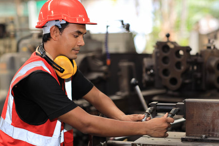 Technician engineer or worker in protective uniform standing and using computer while controlling...