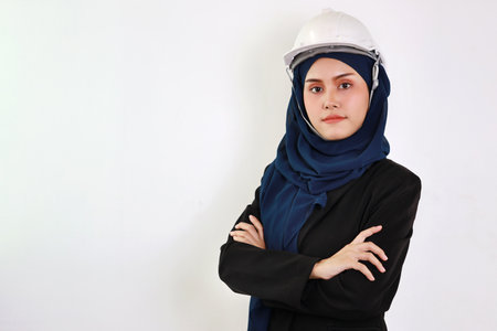 Bueautiful engineer young asian woman wearing blue muslim suit smiling confident in studio. Isolated white background portrait with beautiful face girl with blue hijab. Advertisement portrait concept.の写真素材