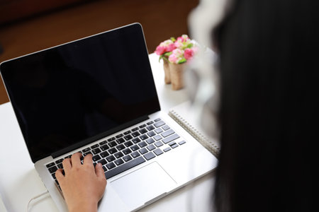 Young smart and active asian female student hands sitting at table with headset, using computer and taking note for studying online with happy smiling face (study only concept)の写真素材
