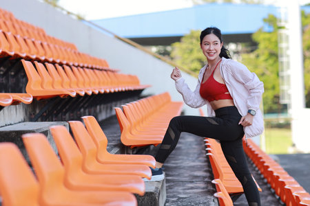Side view strong and beautiful asian fitness female sportswoman morning run and workout at stadium