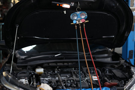 Breakdown vehicle part with car air conditioning system refrigerant recharge at repair garage station. Concept of car center repair service.の写真素材
