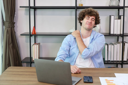Young adult businesswoman touching her neck on table in office after bad news business failure or get fired and feeling discouraged, distraught and hopeless in modern office.の写真素材