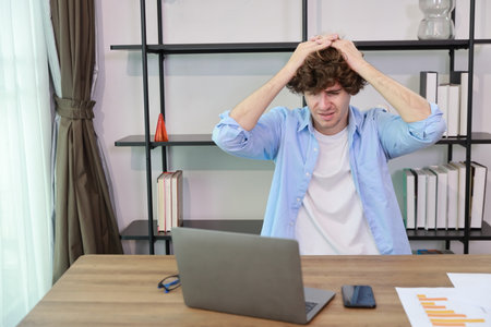 Young adult businesswoman touching his head on table in office after bad news business failure or get fired and feeling discouraged, distraught and hopeless in modern office.の写真素材